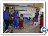 SSAV School Coordinator distributing prize to school students